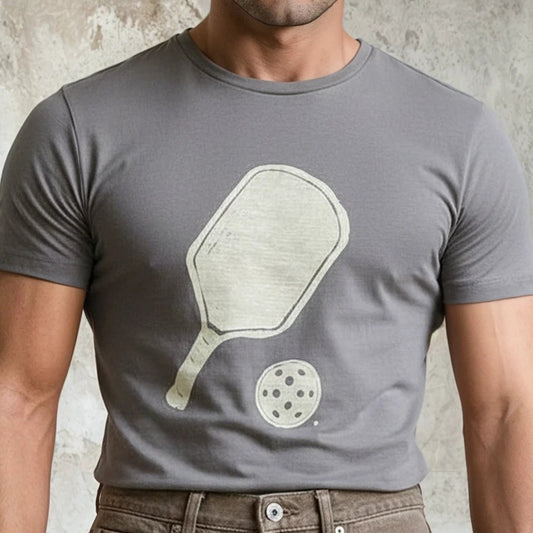 Man wearing a gray t-shirt with a graphic design against a textured wall.