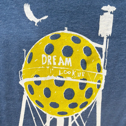 Sea blue t-shirt with a graphic of a water tower and pickleball, featuring text on a blue background.